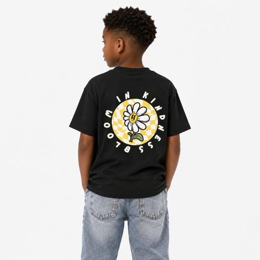 Child wearing a black t-shirt with a flower graphic and text on the back, standing against a white background.