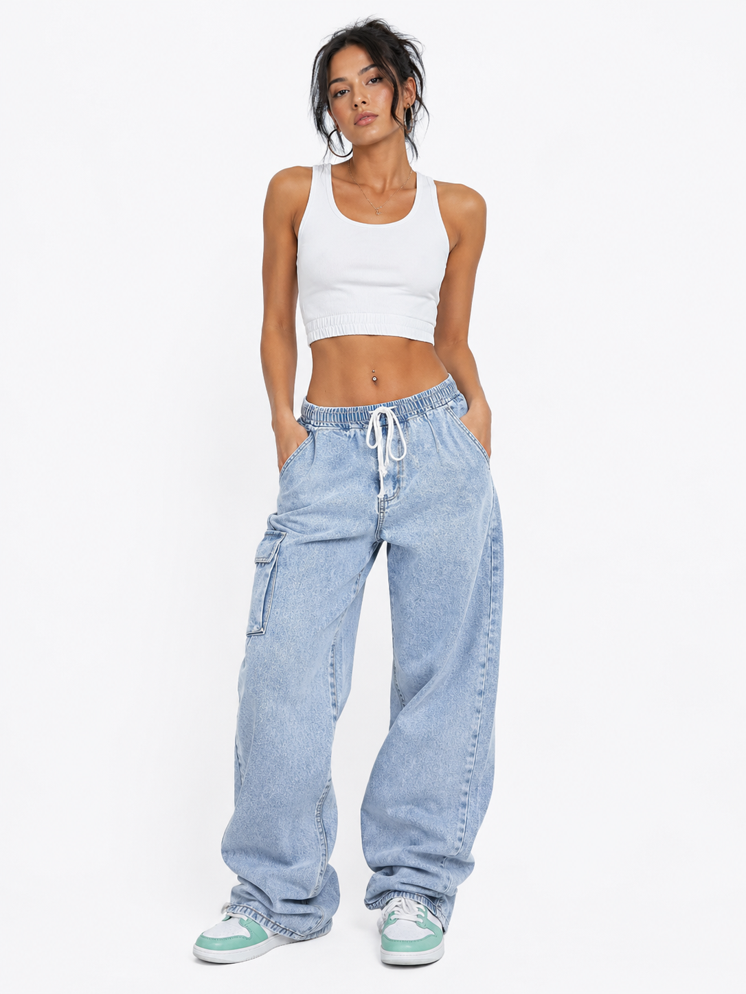Woman wearing a white tank top and light blue jeans on a white background