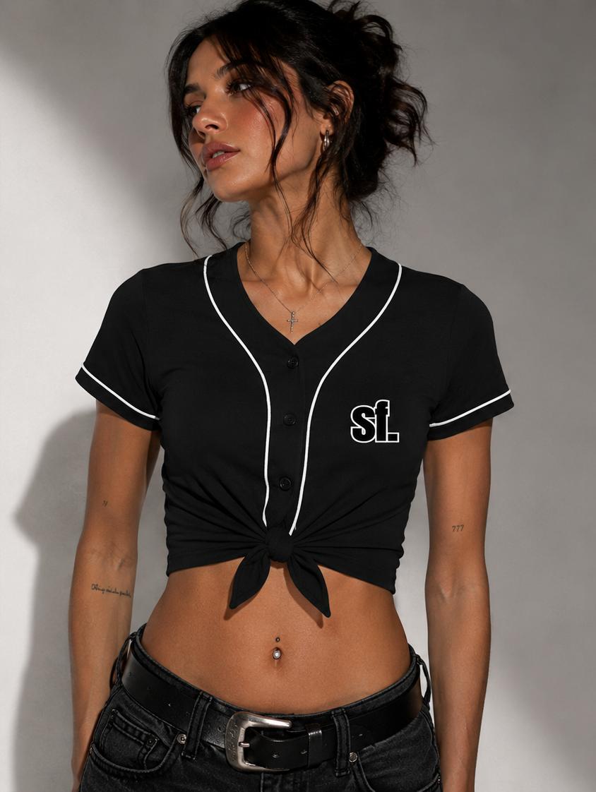 Woman wearing a black crop top with white trim and 'SL' logo, posing against a gray background.