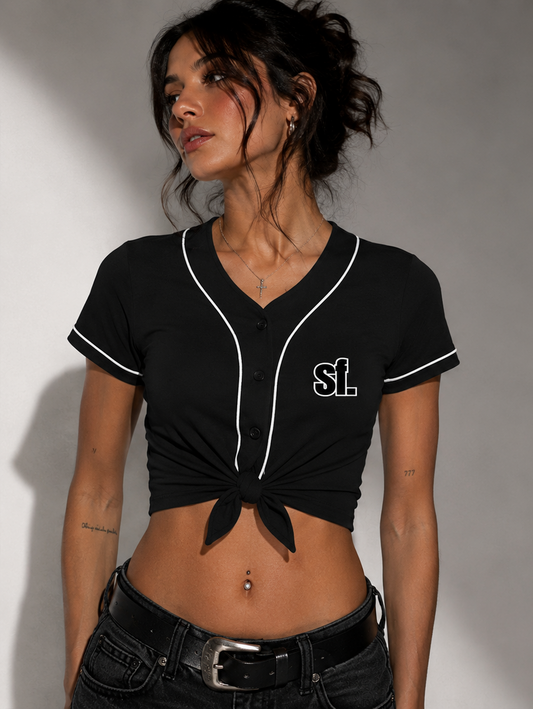 Woman wearing a black crop top with white trim and 'SL' logo, posing against a gray background.