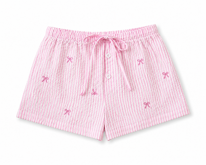 Pink striped shorts with bow details on a white background