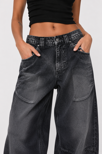Person wearing black jeans and a black top on a white background