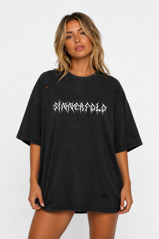 Woman wearing a black oversized t-shirt with white text on a white background
