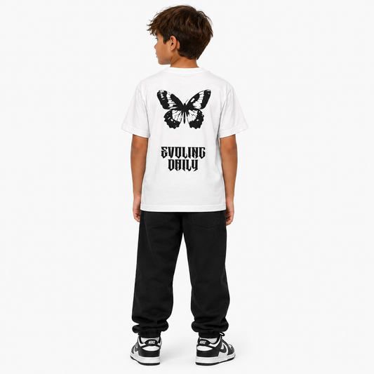 Child wearing a white t-shirt with a butterfly design and text on the back, standing against a white background.