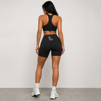 Woman wearing a black athletic outfit with a logo on a plain background