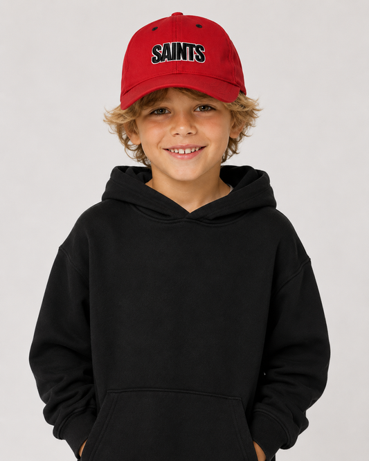 Child wearing a black hoodie and red cap with 'SAINTS' text on a light gray background